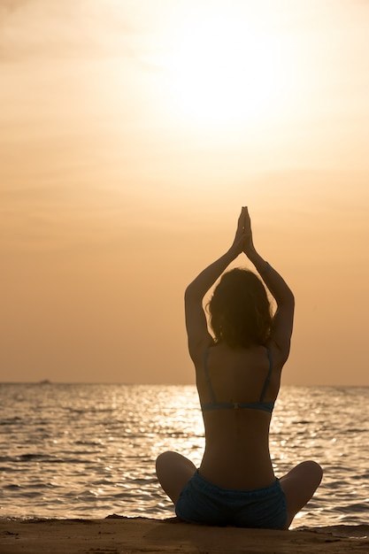 Práctica de yoga en la orilla del mar