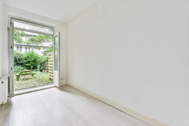 Preciosa imagen de una habitación vacía con exceso a la zona del jardín en una casa blanca de interiorismo