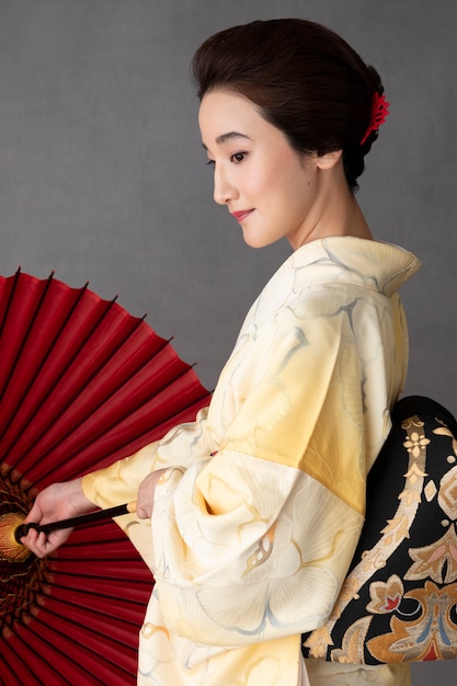 Foto gratuita preciosa modelo japonesa con sombrilla roja