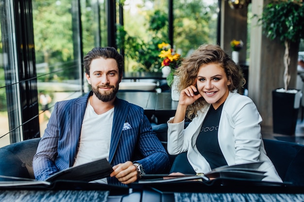 Preciosa pareja joven y bonita con menú en un restaurante haciendo orden