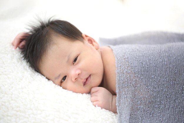 Precioso bebé asiático recién nacido durmiendo en tela peluda