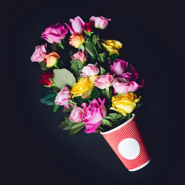 Foto gratuita precioso ramo de rosas coloridas poner en taza de papel rojo