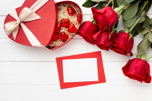 Precioso surtido para la cena del día de San Valentín en fondo blanco de madera con tarjeta vacía