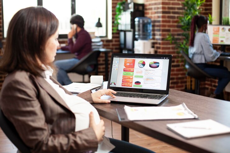 Photo Gratis pregnant woman using laptop at desk