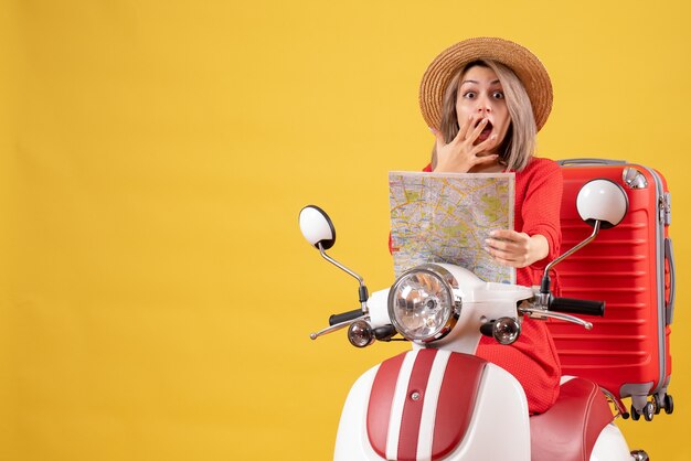 se preguntó chica guapa en ciclomotor con maleta roja sosteniendo el mapa