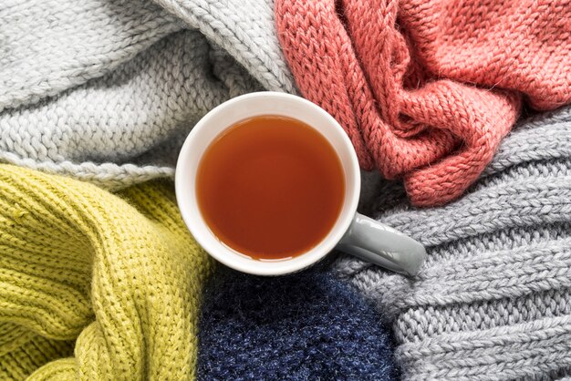 Prendas de punto de colores y taza de té.