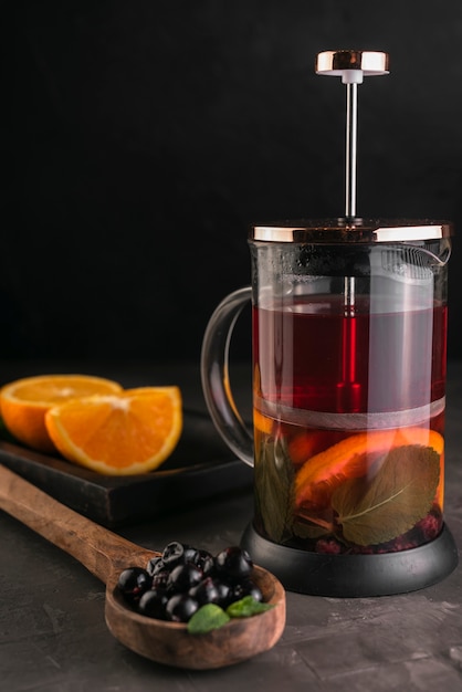 Prensa de té con rodajas de naranja