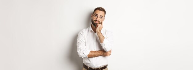 Preocupado manejar mirando hacia otro lado pensativo sintiéndose cansado de pie sobre fondo blanco