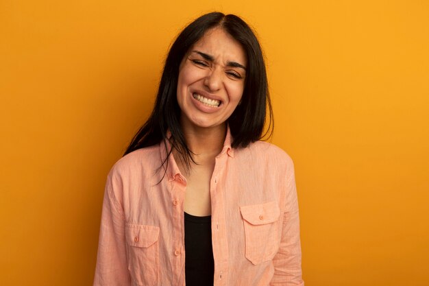 Preocupado por los ojos cerrados joven hermosa vestida con camiseta rosa aislada en la pared amarilla