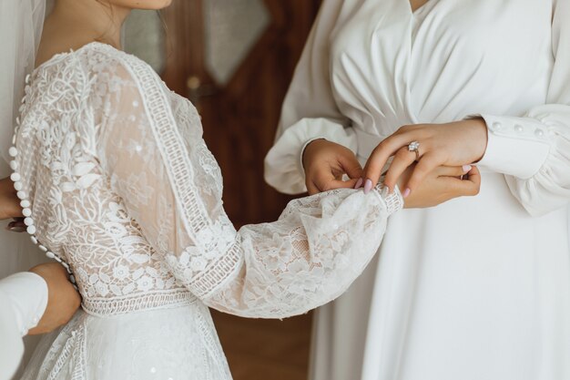 Preparación de la boda, vestir a la novia para la ceremonia de la boda, vista frontal de la vestimenta de la boda