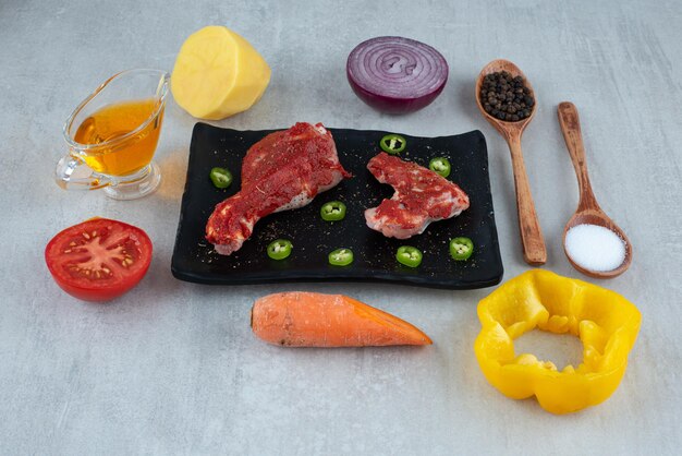 Preparación de pollo con aceite, especias y verduras.