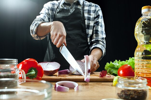 Preparando ensalada. Chef mujer cortando verduras frescas. Proceso de cocción. Enfoque selectivo