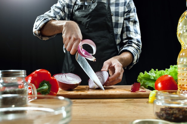 Preparando ensalada. chef mujer cortando verduras frescas.