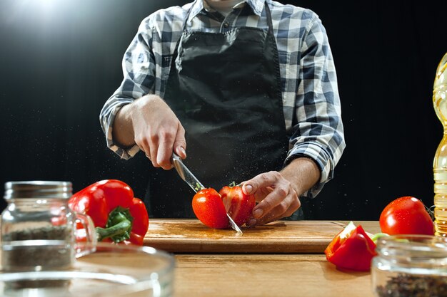 Preparando ensalada. Chef mujer cortando verduras frescas.