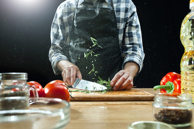 Foto gratuita preparando ensalada. chef mujer cortar verduras frescas. proceso de cocción. enfoque selectivo