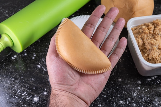 Preparando pastel de pollo brasileño en la mesa