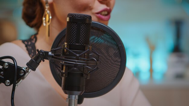 Presentador grabando voz en Home Studio para medios usando un micrófono profesional. Influenciador creativo del programa en línea, presentador del programa de transmisión en línea de la producción en línea en línea que transmite contenido en vivo, recordi