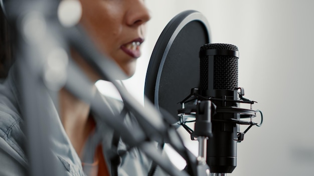 Presentador de programas de radio en vivo en Internet hablando con la audiencia en el micrófono. Creador popular de las redes sociales grabando una entrevista de podcast mientras estaba sentado en el estudio de la sala de estar. De cerca