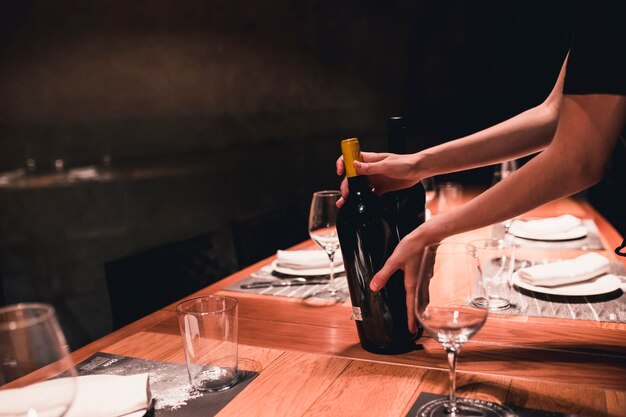 Presentadora de cultivos poniendo vino en la mesa