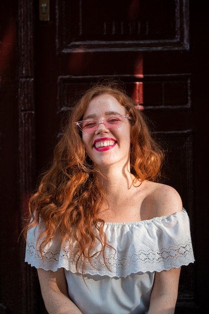 Foto gratuita pretty teen posando delante de una puerta con gafas de sol