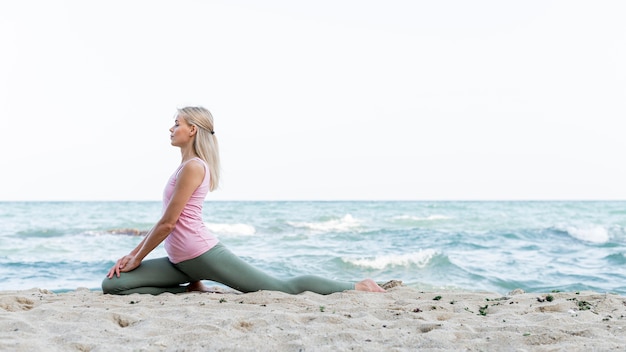 Pretty Woman practicando yoga en la playa.