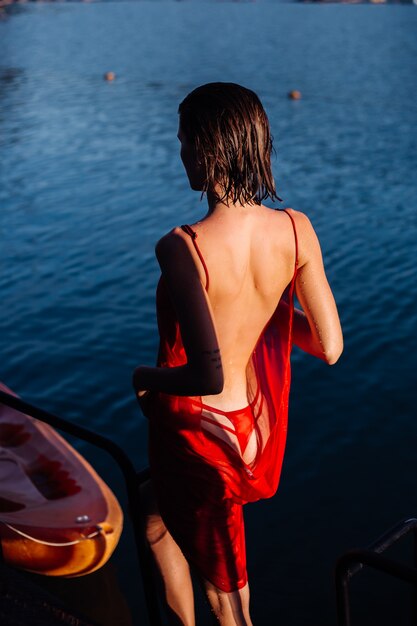 Pretty Woman en vestido de vacaciones, lago y montañas en el fondo