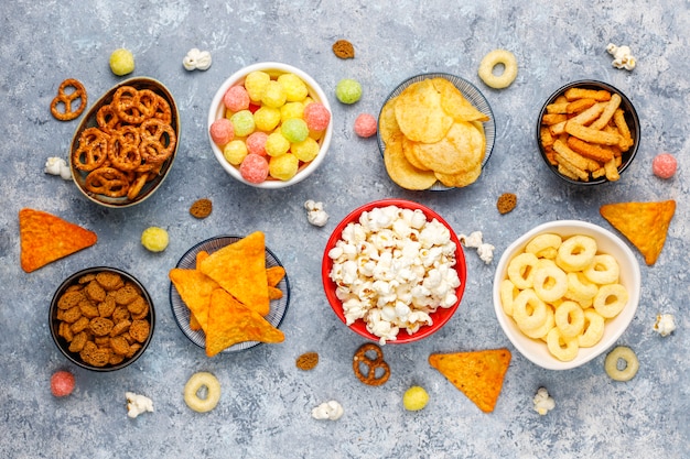 Pretzels, papas fritas, galletas saladas y palomitas de maíz en tazones