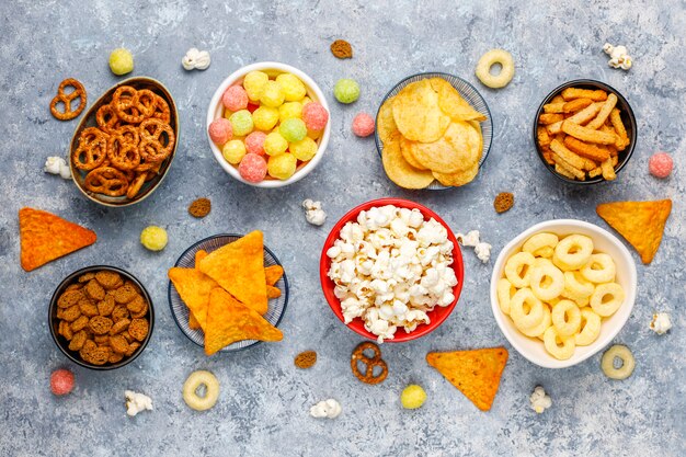 Pretzels, papas fritas, galletas saladas y palomitas de maíz en tazones