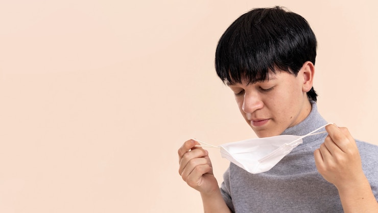 Photo Gratis pria asia dengan tubuh kerdil memegang masker medis