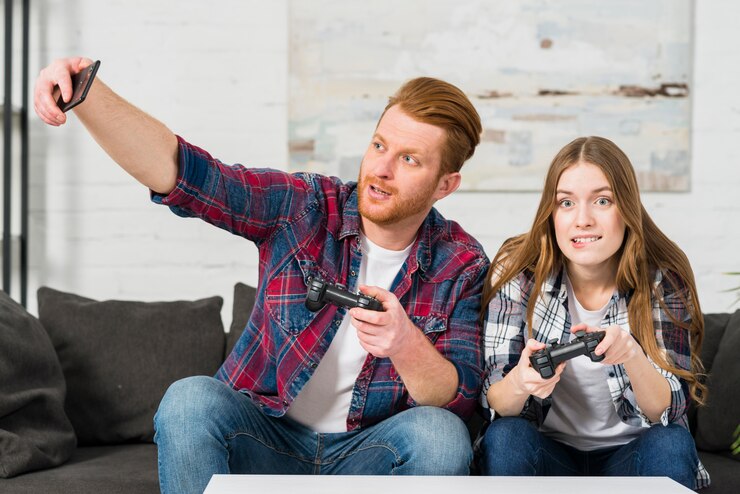 Photo Gratis pria bermain video game dengan pacarnya mengambil selfie di ponsel cerdas