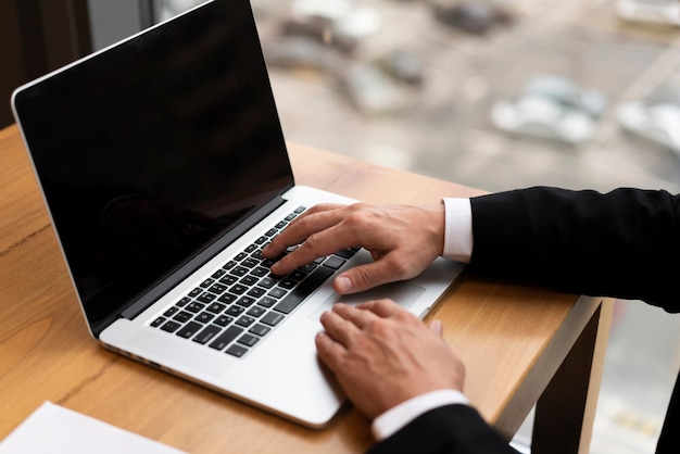 Primer adulto trabajando su computadora portátil en la oficina