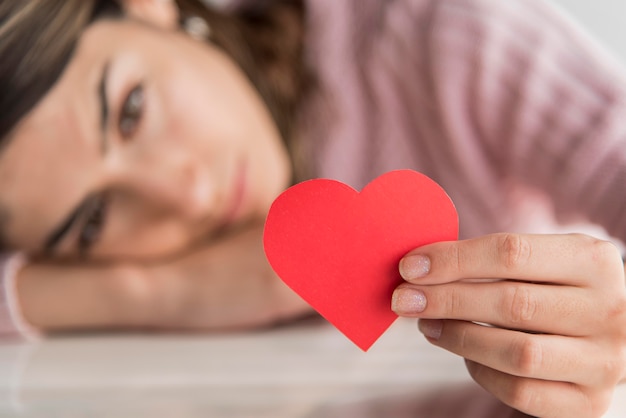 Primer borroso mujer sosteniendo corazón