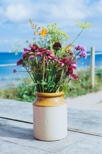 Primer disparo de una hermosa maceta con flores en la mesa de madera