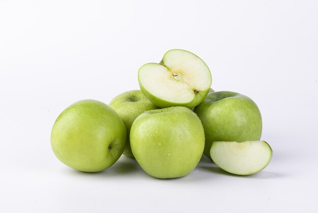 Primer disparo de manzanas verdes frescas en rodajas aislado en la pared blanca