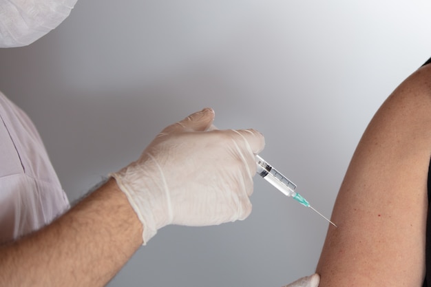 Primer disparo de un médico inyectando una vacuna: el concepto de corona corona