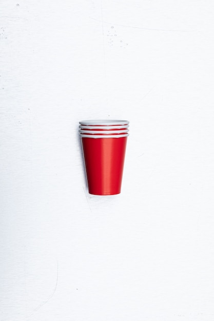 Foto gratuita primer disparo vertical de vasos de papel rojo conjunto aislado sobre un fondo blanco.