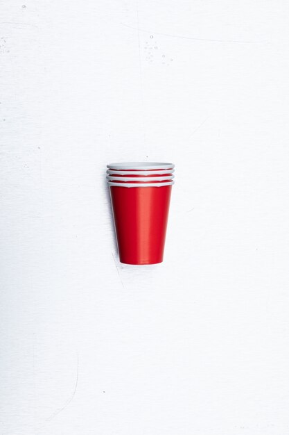 Primer disparo vertical de vasos de papel rojo conjunto aislado sobre un fondo blanco.