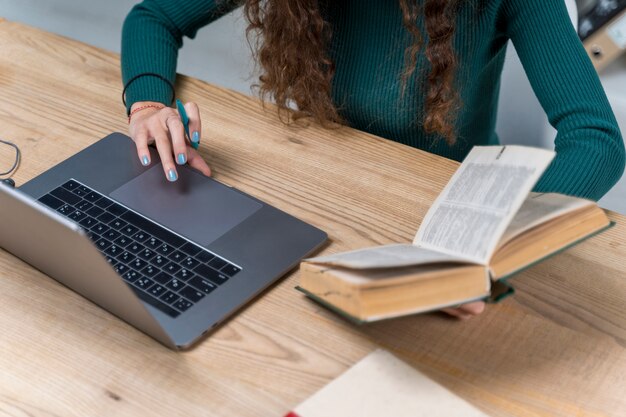 Primer estudiante trabajando con laptop y diccionario