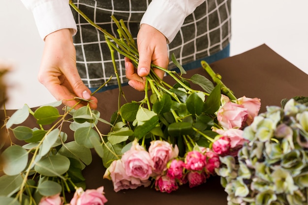 Foto gratuita primer florista arreglando rosas rosadas