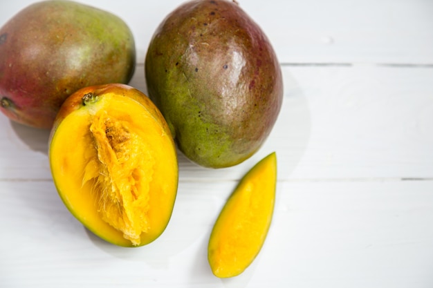 Primer de las frutas del mango en el fondo de madera blanco