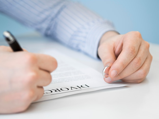 Primer hombre con anillo de matrimonio y contrato de divorcio