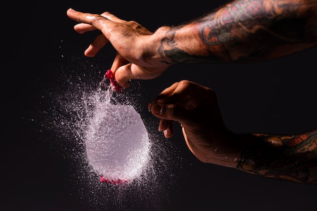 Foto gratuita primer hombre haciendo estallar un globo de agua