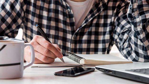 Primer mano escribiendo en el cuaderno