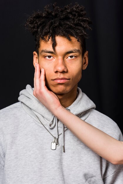 El primer de la mano de la mujer sobre la cara de su novio contra fondo negro