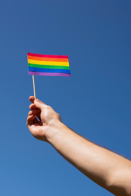 Foto gratuita primer mano sosteniendo la bandera del orgullo gay