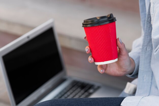 Primer mano sosteniendo una taza de café