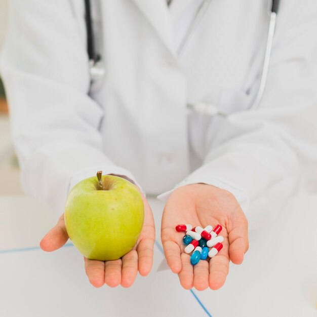 Primer médico con manzana verde y pastillas