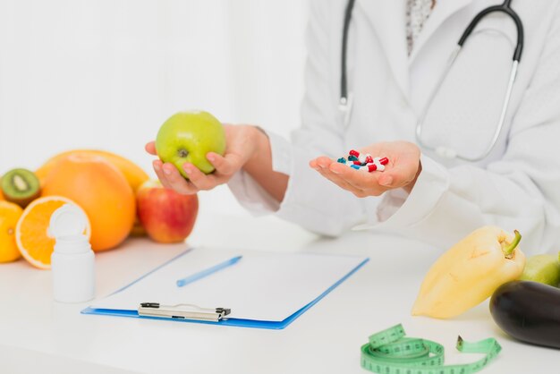 Primer médico con pastillas y frutas frescas