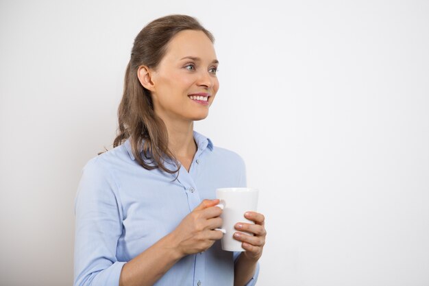 Primer de la mujer bonita joven con la taza positiva