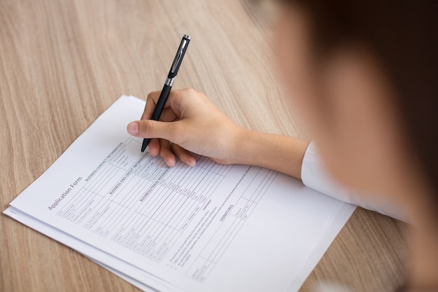 Foto gratuita primer de la mujer solicitante que llena el formulario